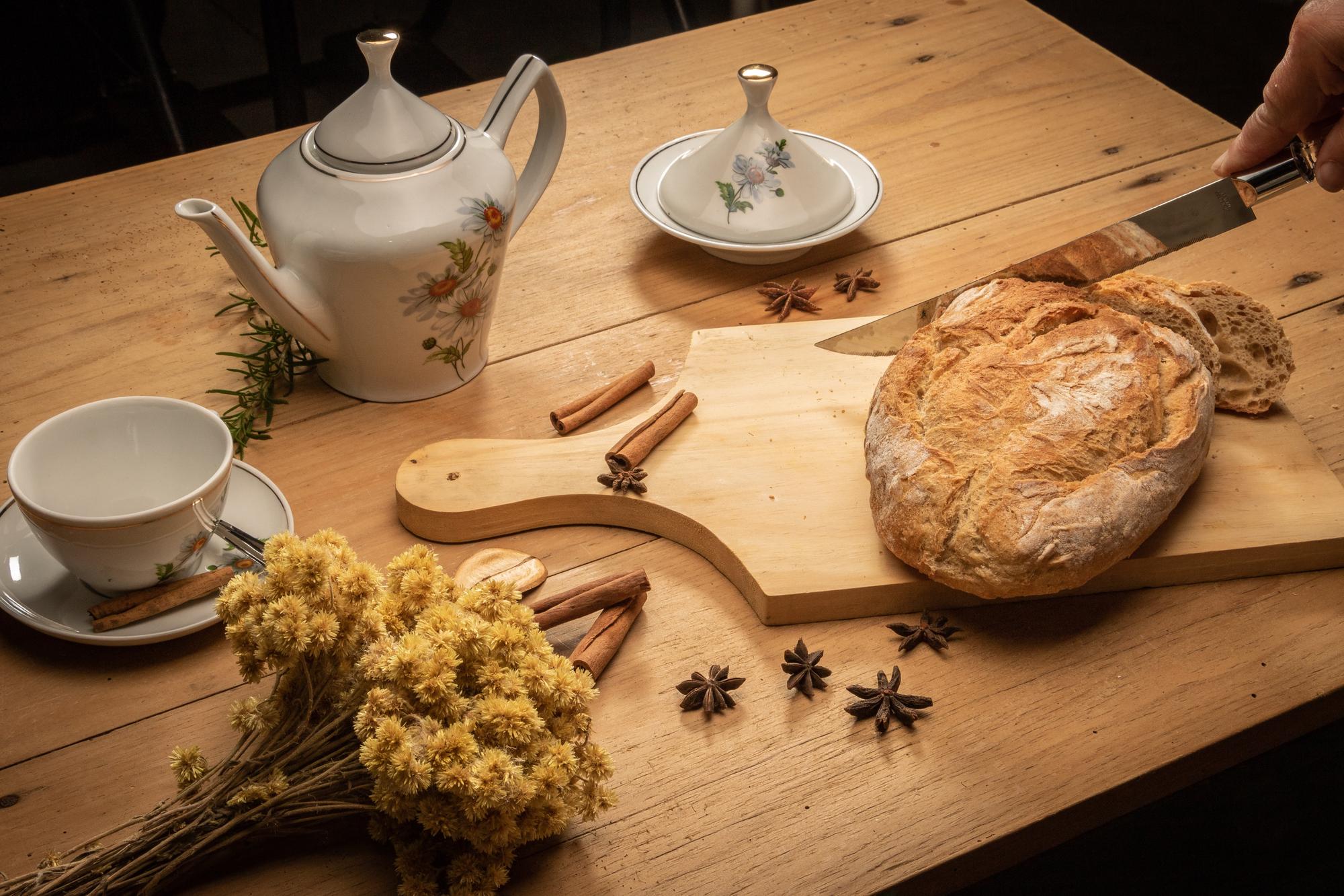 Close up of artisan bread and herbs on wooden table